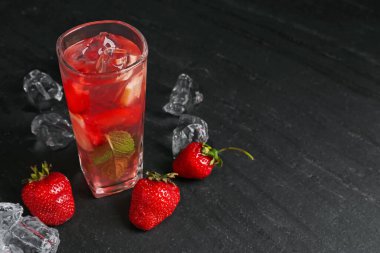 Çilekli içecek ve koyu dokulu masa üzerinde buz, yakın çekim. Metin için boşluk