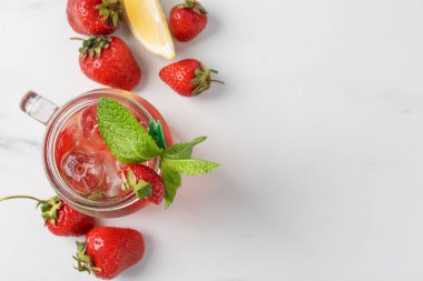 Çilekli içecek, buz ve nane şekeri beyaz masada, düz yerde. Metin için boşluk