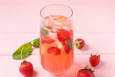 Çilekli içecek, pembe ahşap masadaki nane ve buz, yakın plan.