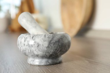 Mutfaktaki ahşap masada mermer harç ve tokmak, yakın plan. Metin için boşluk