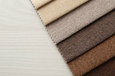 Açık ahşap masadaki farklı kumaşlardan örnekler, üst manzara. Metin için boşluk