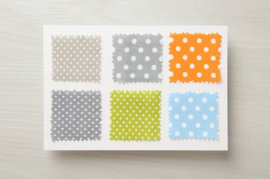 Hafif ahşap masa üzerinde benekli kumaş örnekleri, üst görünüm