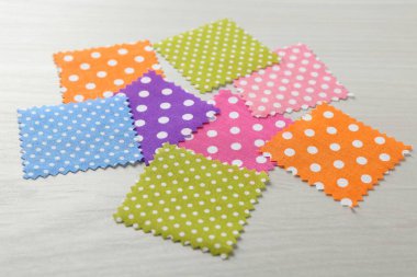 Beyaz ahşap masadaki farklı kumaşlardan örnekler, yakın plan.