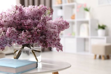 Vazodaki güzel leylak çiçekleri ve içerideki masada kitap, metin için yer