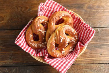 Hasır sepetin içinde tuzlu krakerler, ahşap masa, üst manzara.