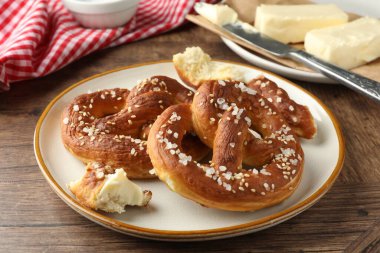 Ahşap masada tuz ve tereyağlı lezzetli krakerler, yakın plan.