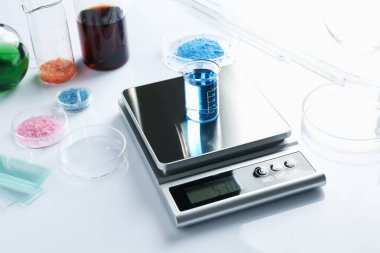 Beyaz arka planda deney tüpü ve diğer laboratuvar ekipmanlarıyla ölçeklendir