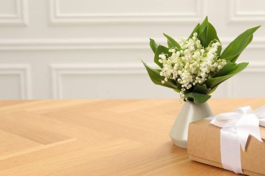 Vadi çiçeklerinin güzel zambakları ve ahşap masada hediye. Metin için boşluk