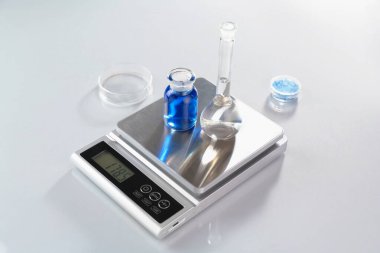 Örnekler ve laboratuvar camlarıyla beyaz masa üzerinde renk ışıklarıyla ölçeklendir, yakın plan