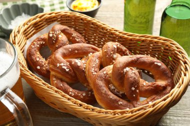 Sepette lezzetli krakerler ve ahşap masada bira, yakın plan.