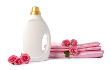 Bir şişe yumuşatıcı, üst üste yığılmış giysiler ve beyaza saklanmış çiçekler.