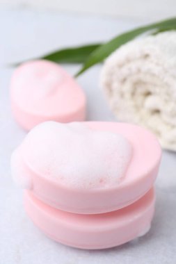 Beyaz masadaki köpüklü sabun çubukları, yakın plan.