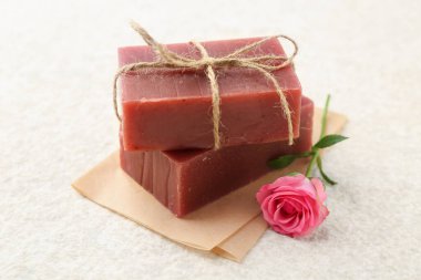 Sabun çubukları ve bej masadaki güzel gül, yakın plan.