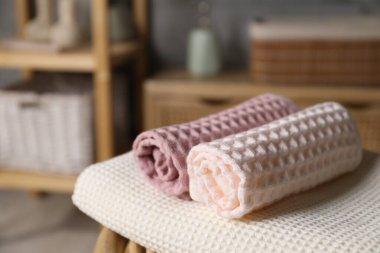 Banyodaki sandalyede temiz waffle havluları, yakın plan.