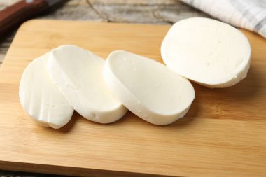 Ahşap masada mozzarella peyniri kes, yakın plan.