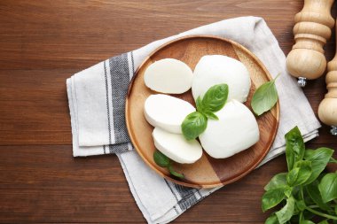 Lezzetli mozarella peyniri parçaları, fesleğen yaprakları ve sallanan ahşap masa, düz yatıyordu.