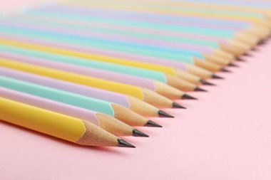 Many graphite pencils on pink background, closeup