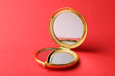 Kırmızı arkaplanda cep aynasını aç, kapat