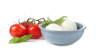 Beyaz arka planda lezzetli mozzarella peynir topları, domates ve fesleğen.