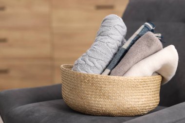 İçerideki koltukta hasır sepetteki yün giysiler.