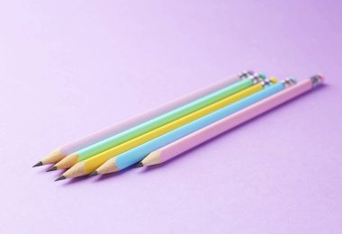 Menekşe arkaplan üzerinde birçok grafit kalem, yakın plan