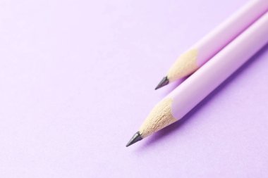 Menekşe arka planda iki grafit kalem, yakın plan. Metin için boşluk