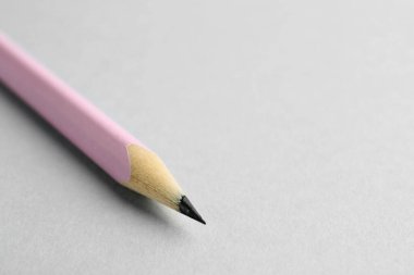 Açık gri arka planda bir grafit kalem, yakın plan. Metin için boşluk