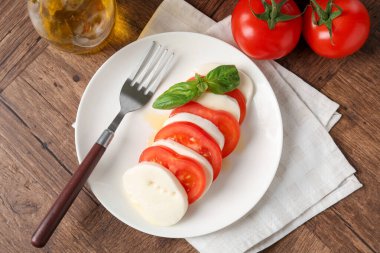 Lezzetli mozzarella, domates, yağ ve fesleğen ahşap masa, düz yatıyordu.