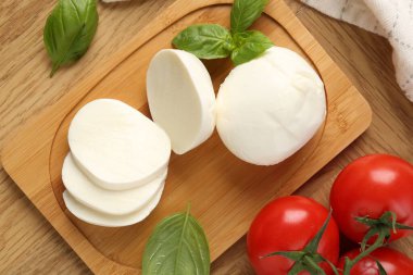 Lezzetli mozzarella, domates ve fesleğen, ahşap masa, düz uzanma