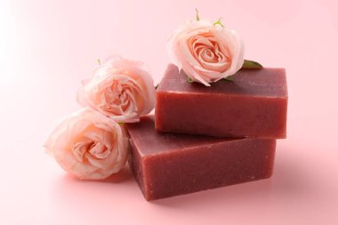 Sabun çubukları ve pembe arka planda güzel güller, yakın plan.