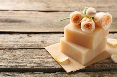 Sabun çubukları ve ahşap masada güzel güller, yakın plan. Metin için boşluk