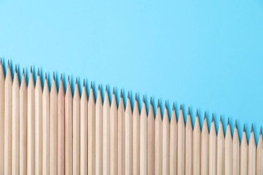 Açık mavi zemin üzerinde birçok grafit kalem, düz yatıyordu. Metin için boşluk