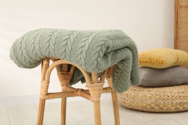 İçerideki taburede yeşil yün battaniye, yakın plan.