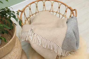 Yünlü battaniyeler sepette. Evin içinde, manzaranın üstünde.