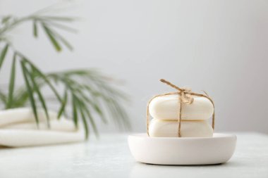 Beyaz masadaki sabun çubukları gri arka plana karşı, yakın plan. Metin için boşluk