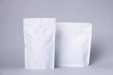 Açık gri arka planda fermuarlı stand-up kesesi. Tasarım için model