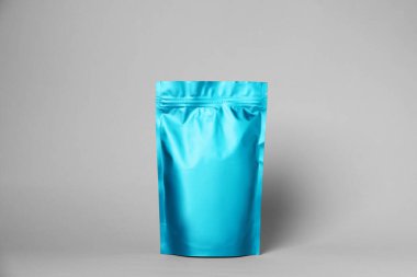 Açık gri arka planda fermuarlı bir stand-up kesesi. Tasarım için model