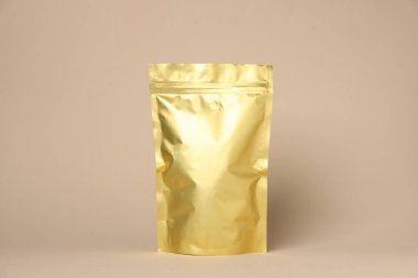 Bej arka planda fermuarlı bir stand-up kesesi. Tasarım için model