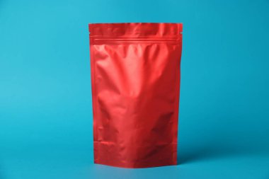 Açık mavi arka planda fermuarlı bir stand-up kesesi. Tasarım için model