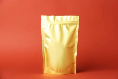 Kırmızı arka planda fermuarlı bir stand-up kesesi. Tasarım için model