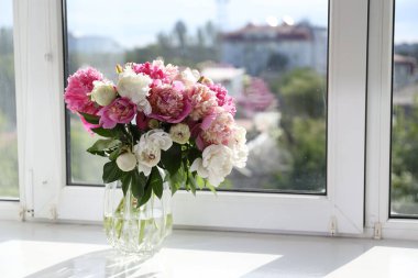 Pencere pervazında vazoda bir buket güzel şakayık, metin için yer var.