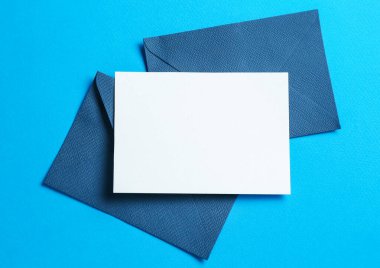 Açık mavi arka planda boş davetiye ve zarflar. Tasarım için boşluk