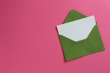 Pembe arka planda boş davetiye ve zarf, üst manzara. Metin için boşluk