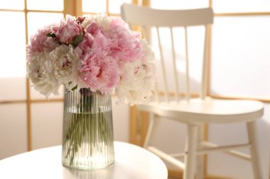 Beyaz masadaki vazodaki güzel şakayıklar, metin için yer.