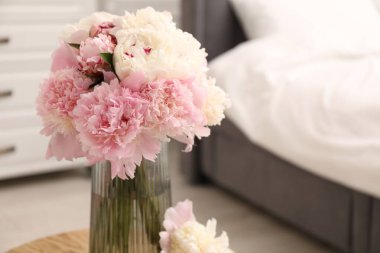 İçerideki ahşap masada vazodaki güzel şakayıklar, yakın plan. Metin için boşluk