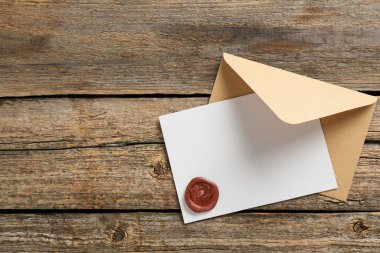 Üzerinde balmumu mühür ve ahşap masa manzaralı boş bir davetiye kartı. Tasarım için boşluk