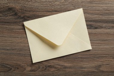 Tahta masanın üstünde güzel bir davetiye zarfı, üst manzara.