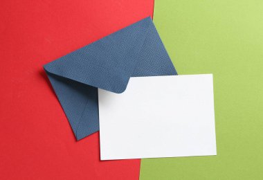 Renk arkaplan üzerinde boş davetiye ve zarf, üst görünüm. Tasarım için boşluk