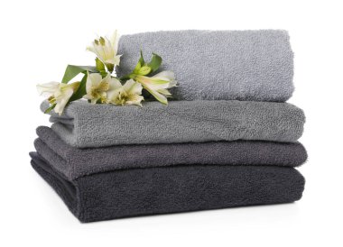 Havlu yığını ve beyaz üzerine izole edilmiş güzel çiçekler.