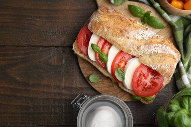 Peynirli, domatesli, ahşap masadaki fesleğenli lezzetli sandviç. Metin için boşluk